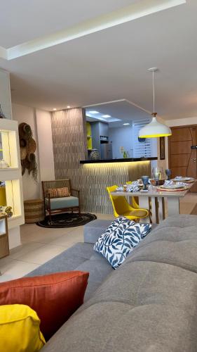 a living room with a couch and a dining room at Praia Grande Arraial do Cabo in Arraial do Cabo