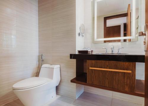 a bathroom with a white toilet and a sink at VELA OCEAN LUXURY SUITES Nha Trang Centre in Nha Trang