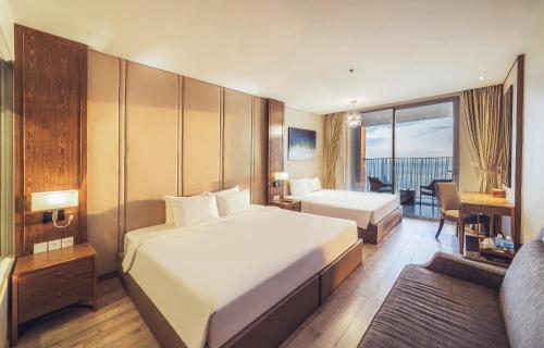 a hotel room with two beds and a balcony at VELA OCEAN LUXURY SUITES Nha Trang Centre in Nha Trang