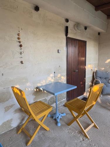 a blue table and two chairs in front of a building at Villa Donna Sibilla in Merine
