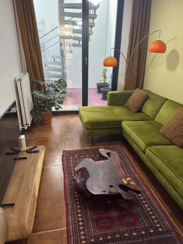 a living room with a green couch and a rug at Le Souterrain in Antwerp