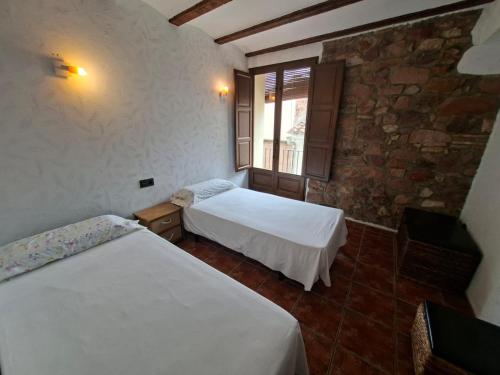 una camera da letto con due letti e una finestra di LA COVETA RURaL a Vilafamés