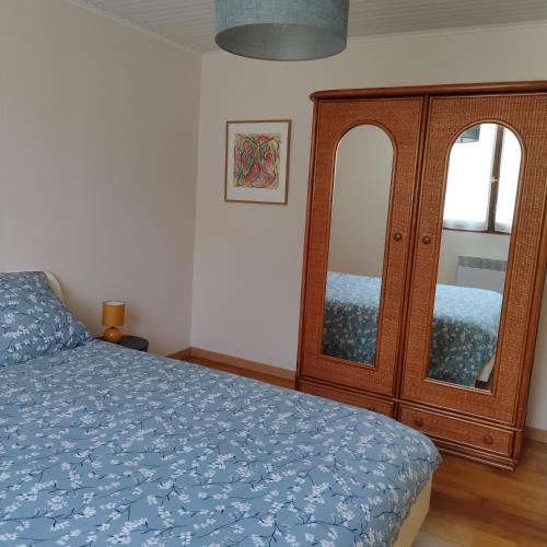 Un dormitorio con una cama y un armario de madera. en Maison de plein pied et tranquille, en Sanguinet