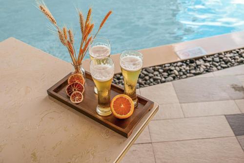 a tray with four glasses of beer and orange slices at VELA OCEAN LUXURY SUITES Nha Trang Centre in Nha Trang