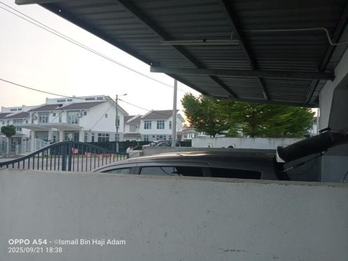 a car parked in a parking lot next to houses at Izdaan Homestay in Jasin