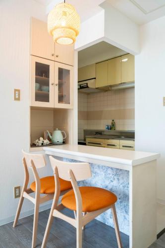a kitchen with two chairs and a white counter top at ダイナスティパレス58 in Sapporo