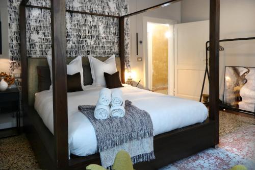 a bedroom with a bed with two pairs of slippers at Addler House Apt by Addler House Ospitality in Mestre