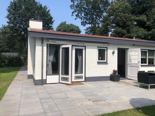 a small white house with a patio at Holiday Home in Harderwijk near Veluwemeer in Harderwijk