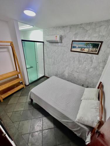 a bedroom with a bed in a room with a wall at Cantinho na praia in Arraial do Cabo