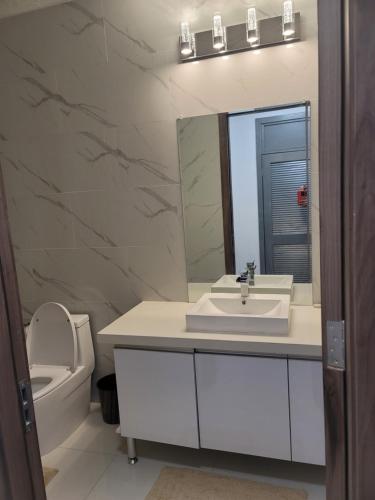 une salle de bains avec lavabo, toilettes et miroir dans l'établissement Nesty Place, à Kingston