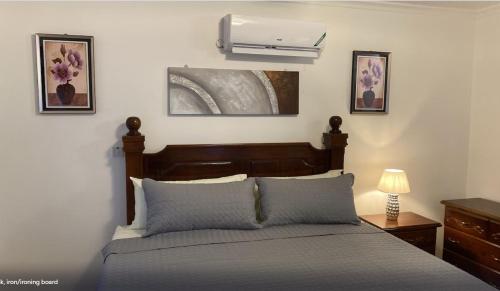 une chambre avec un lit et un climatiseur mural dans l'établissement Nesty Place, à Kingston