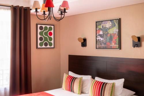 a bedroom with a bed and a chandelier at Chatillon Paris Montparnasse in Paris