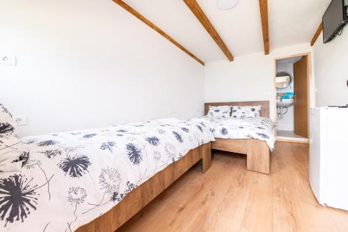 a bed in a room with a wooden floor at Colours Plus in Sarajevo