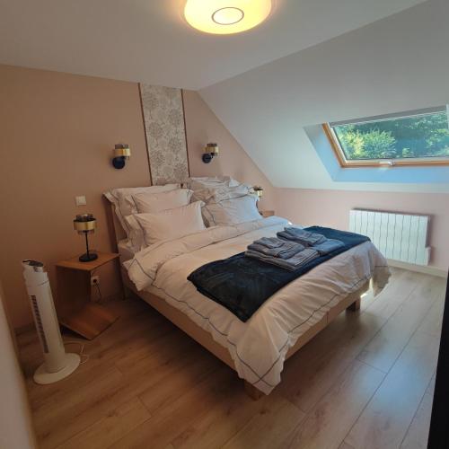 a bedroom with a bed with white sheets and a window at Au Coeur du Verger in Thiescourt