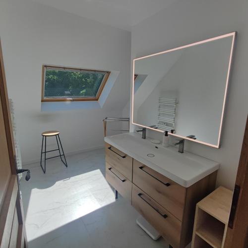 a bathroom with a mirror and a sink and a stool at Au Coeur du Verger in Thiescourt