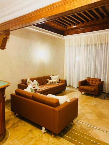 a living room with two brown couches in a room at Palmeraie village , lieu exceptionnel avec jardin et piscine in Marrakech