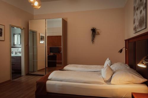 a bedroom with a bed with white sheets and pillows at Alpenstadthotels in Bad Reichenhall