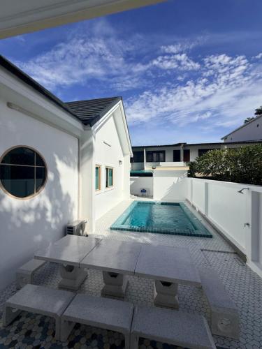 a swimming pool in the backyard of a house at วันบางแสนพูลวิลล่า One Bangsaen Poolvillas in Ban Bang Saen (1)