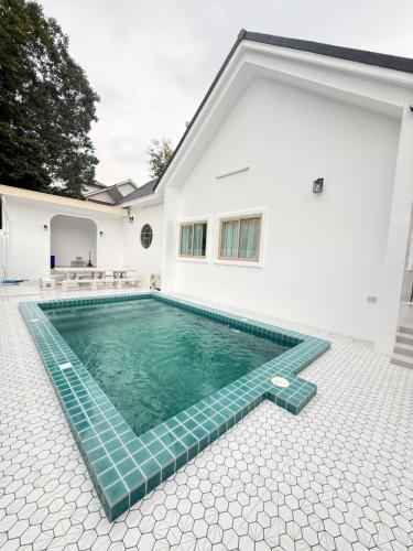 a swimming pool in the backyard of a house at วันบางแสนพูลวิลล่า One Bangsaen Poolvillas in Ban Bang Saen (1)