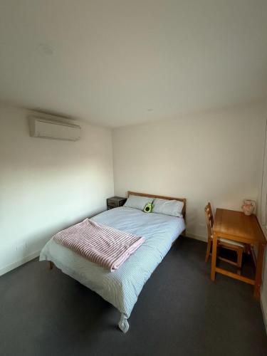 une petite chambre avec un lit et une table dans l'établissement Modern Stylish Comfort at Prime Camberwell Retreat, à Camberwell