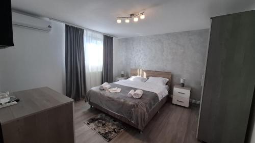 a bedroom with a bed with two towels on it at Casa Medeea in Podu Turcului