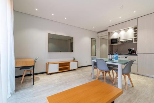 a living room with a table and chairs and a kitchen at Smartr Porto Gaia in Vila Nova de Gaia