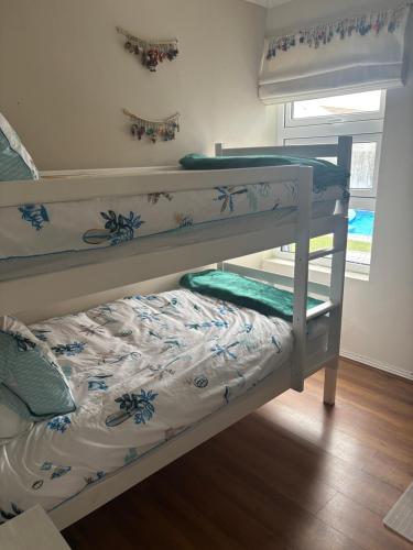 deux lits superposés dans une chambre avec un lit dans l'établissement Family Home in West Beach, Blouberg, au Cap