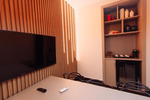 a conference room with a table and a large flat screen tv at Sttudio One in Araxá