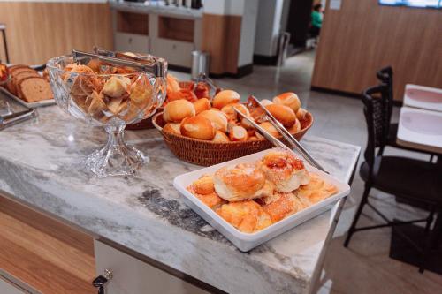 a table with a bunch of pastries and a bowl of bread at Sttudio One in Araxá