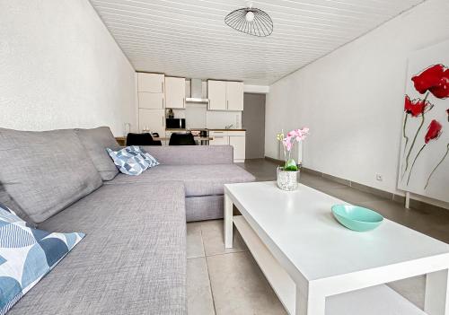 una sala de estar con un sofá y una mesa en Parking privé & terrasse ensoleillée, en Illzach