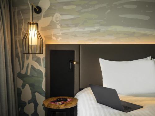 a bedroom with a bed with a laptop on it at Mercure Bedford Centre Hotel in Bedford
