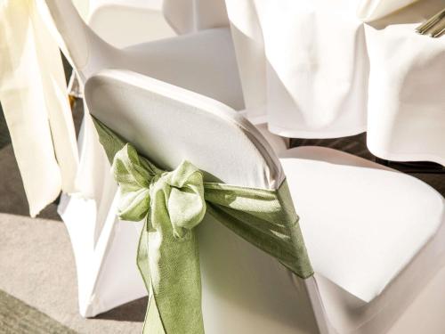 a white chair with a green bow on it at Mercure Bedford Centre Hotel in Bedford
