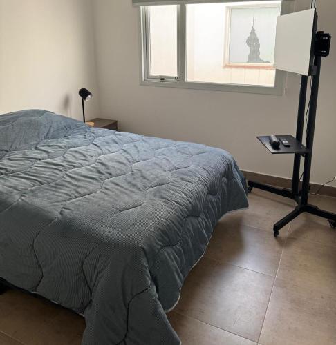 una camera da letto con un letto, un tavolo e una finestra di CentroTrelew a Trelew