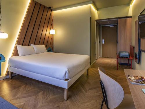 a bedroom with a large white bed and a table at Ibis Styles Madrid City Las Ventas in Madrid