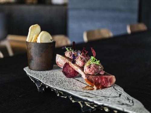 a plate of food with meat and bread on a table at Ibis Styles Madrid City Las Ventas in Madrid