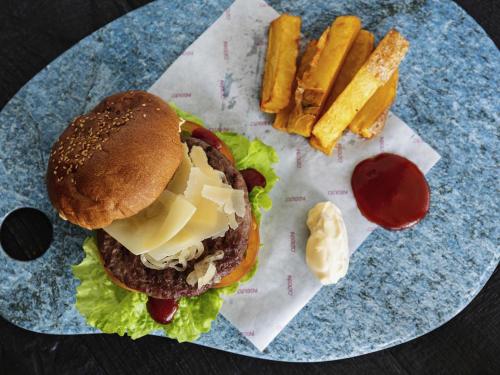 a plate with a hamburger and french fries and ketchup at Ibis Styles Madrid City Las Ventas in Madrid