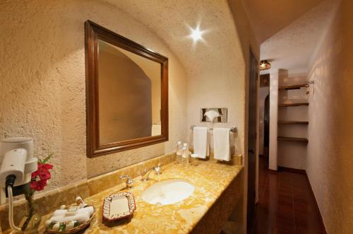 a bathroom with a sink and a mirror at Villas Arqueologicas Chichen Itza in Chichén-Itzá