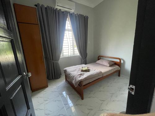 a small bedroom with a bed and a window at D Raihan Guest House in Ketereh