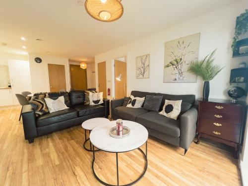 a living room with two couches and a table at Manchester Waterside Retreat in Manchester