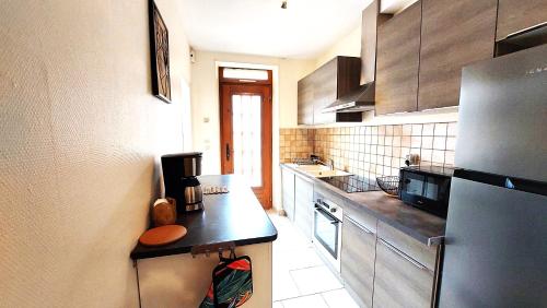 a kitchen with a refrigerator and a counter top at Maison centre ville in Nogent-sur-Vernisson