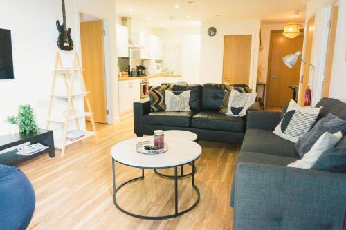 a living room with a couch and a table at Manchester Waterside Retreat in Manchester