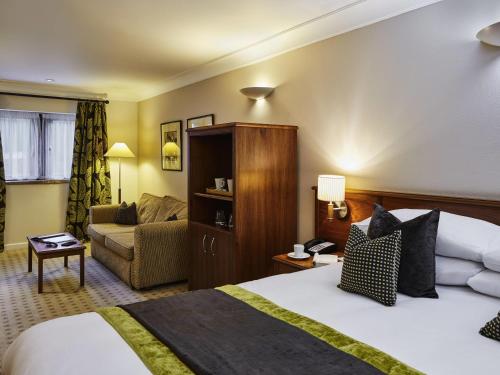 a hotel room with a bed and a couch at Mercure Barnsley Tankersley Manor Hotel in Barnsley