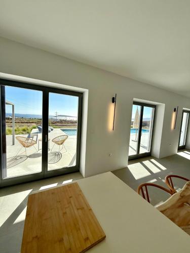 a living room with a table and a view of the ocean at Faragas Hill Harmony Villa in Angairiá