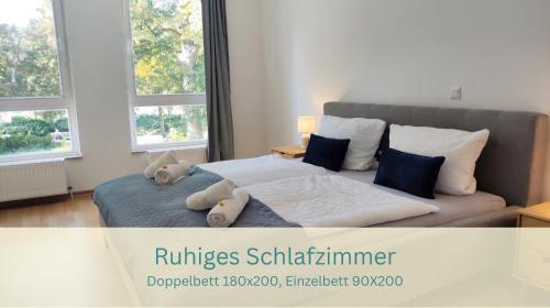 a bedroom with a bed with two stuffed animals on it at Im Herzen der Kurstadt, Balkon, Küche, Blick ins Grüne, radfreundlich in Bad Schmiedeberg