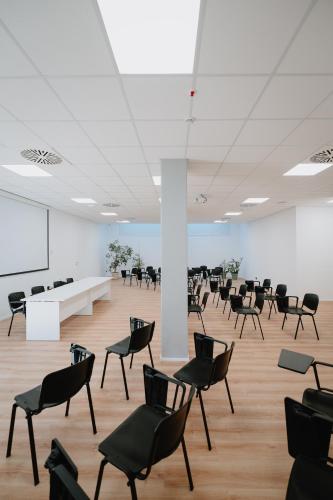 an empty room with chairs and a white wall at Eden Hotel in San Salvo