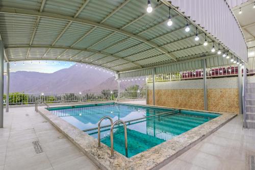 a large swimming pool with an open ceiling at The Sunshine Farm by Al Dana Paradise Luxury 6BR Secluded Nature Mountains in Khor Fakkan
