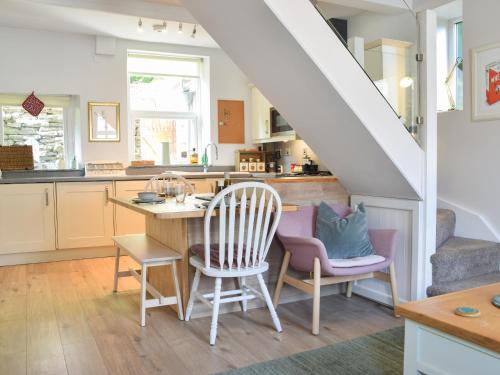 a kitchen with a table and chairs and a staircase at Hillside Cottage in Glossop
