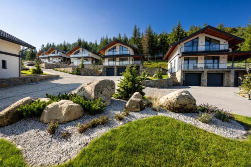 a house with rocks in the yard at EcoBerghaus - Котеджне містечко in Bukovel