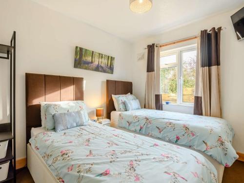 a bedroom with two beds and a window at 2 Bed in Thornicombe 90161 in Charlton Marshall