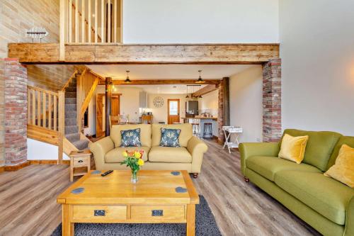 a living room with two couches and a coffee table at Monks Barn in Upwell
